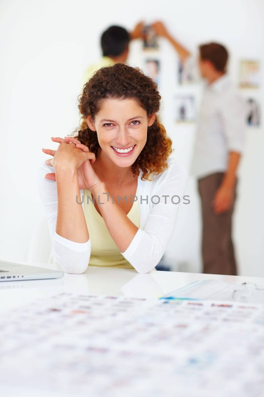 Business woman smiling. Portrait of business woman smiling with colleagues in background. by YuriArcurs