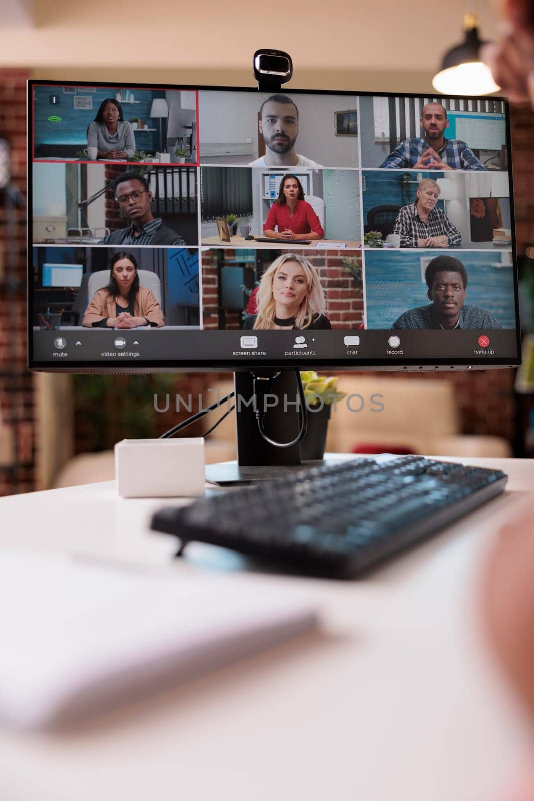 Closeup of computer screen with video conference app and webcam showing diverse team of startup employees. Selective focus on pc monitor with colleagues in internet call brainstorming ideas.