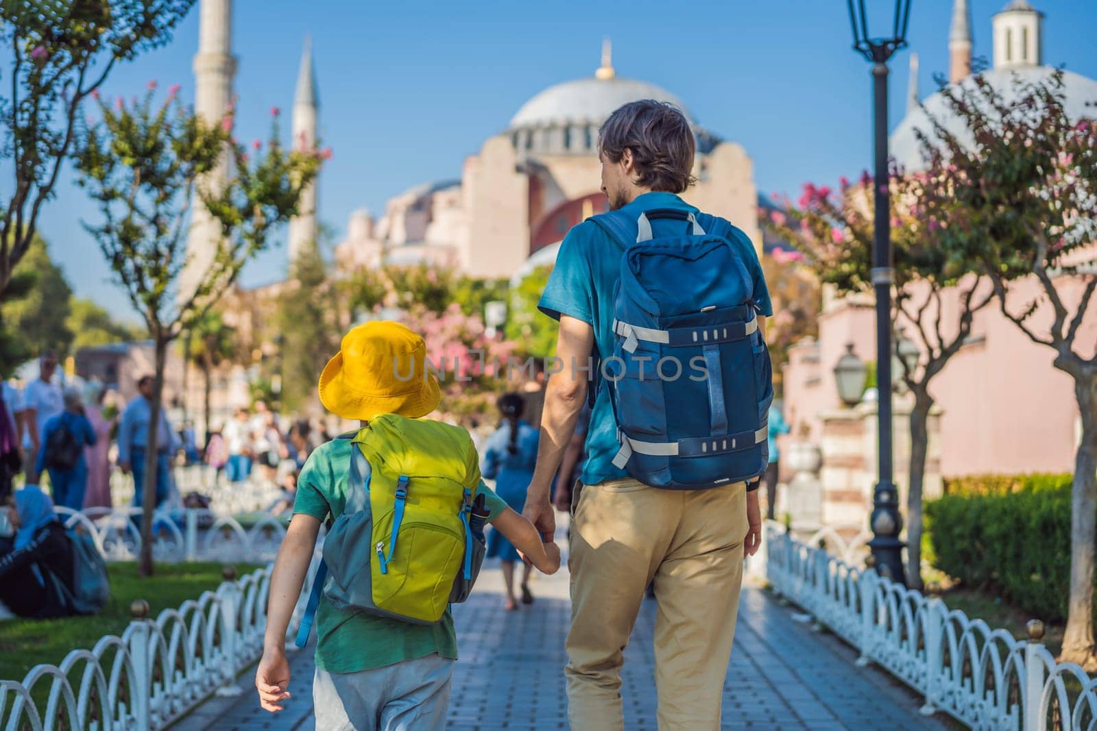 Father and son Tourists enjoy beautiful view on Hagia Sophia Cathedral, famous islamic Landmark mosque, Travel to Istanbul, Turkey. Traveling with kids concept. Sunny day architecture and Hagia Sophia Museum, in Eminonu, istanbul, Turkey. Turkiye.