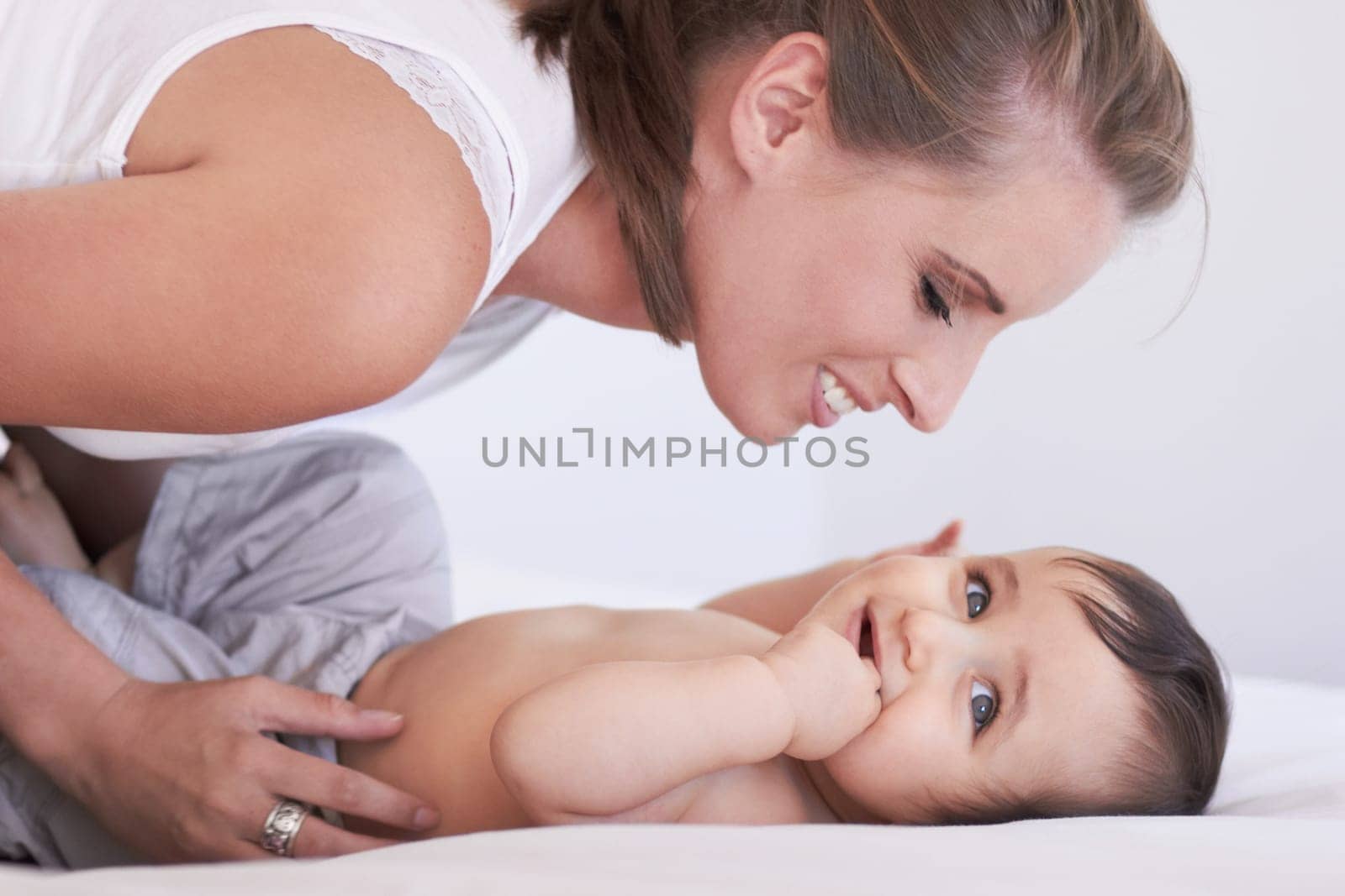 Mother, happy and baby smile at home on diaper changing table with happiness. Family, house and young child with mom feeling love, care and parent support from bonding together with cute kid and mama.