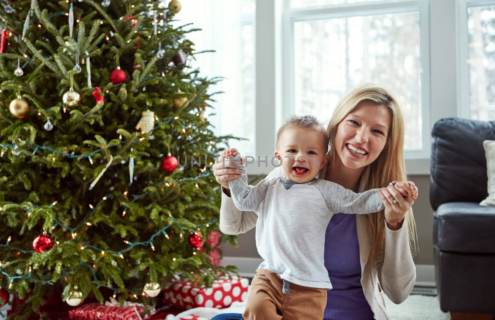 He makes the most wonderful time even more wonderful. a young mother enjoying Christmas with her little boy