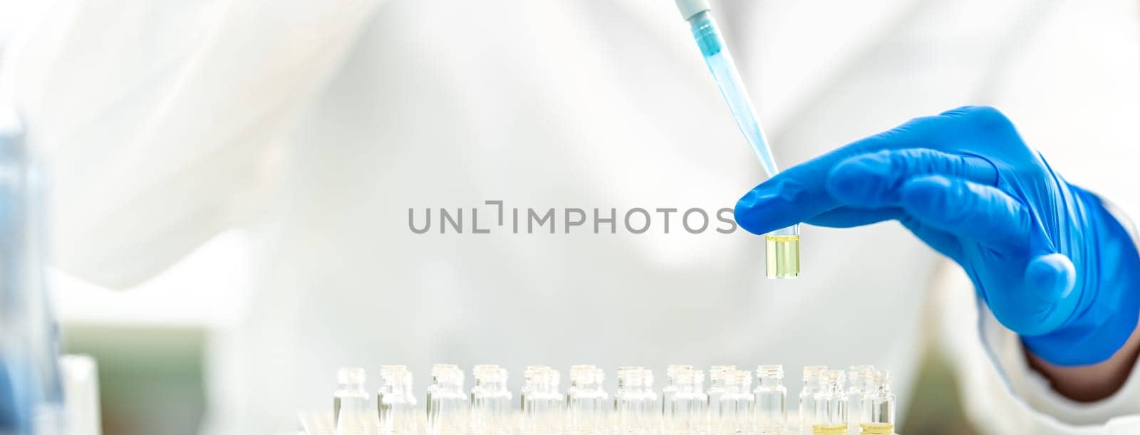 pipetting a chemical sample into research flasks. High quality photo