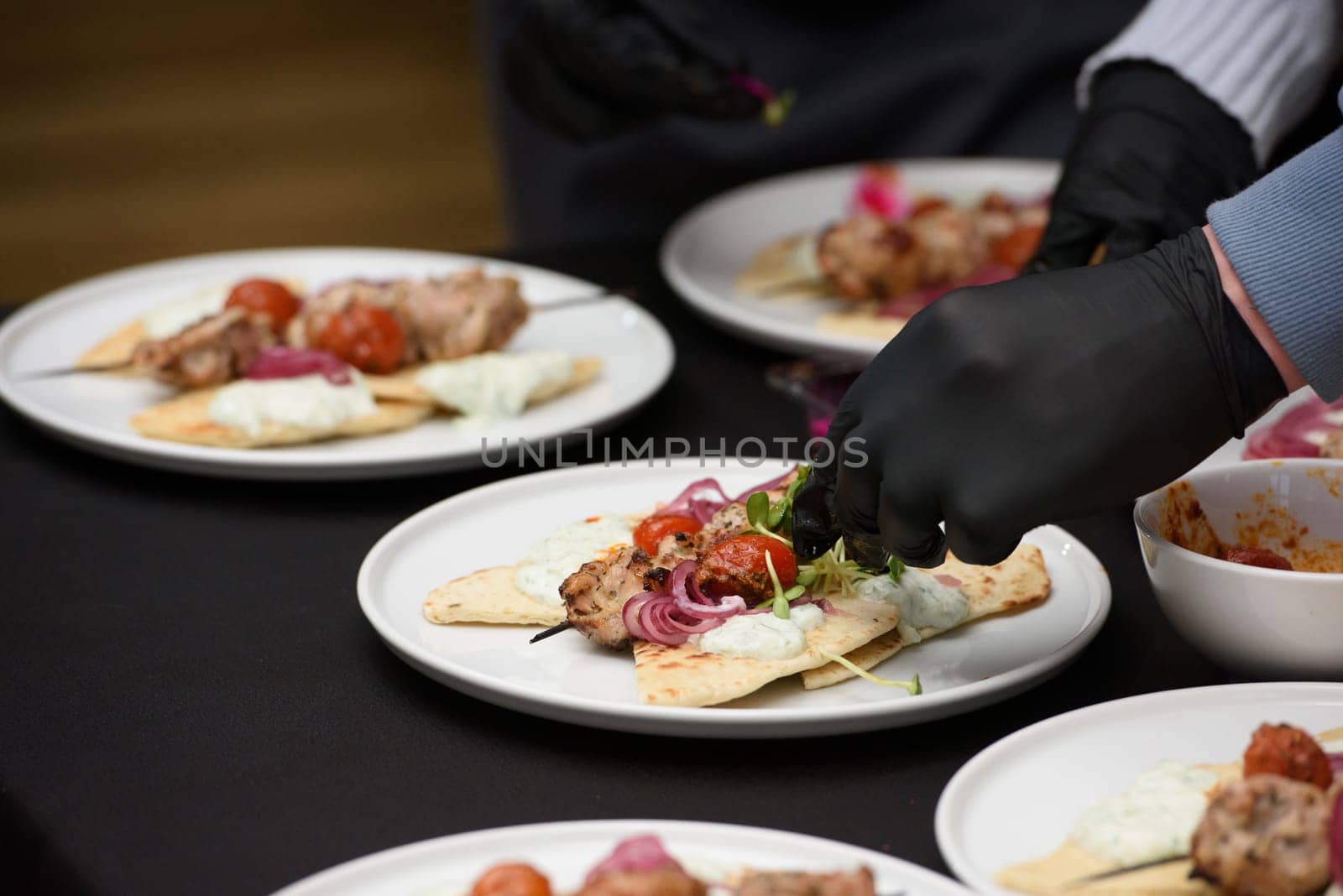 the chef in the restaurant prepares souvlaki with pita and tzatziki sauce by Ashtray25