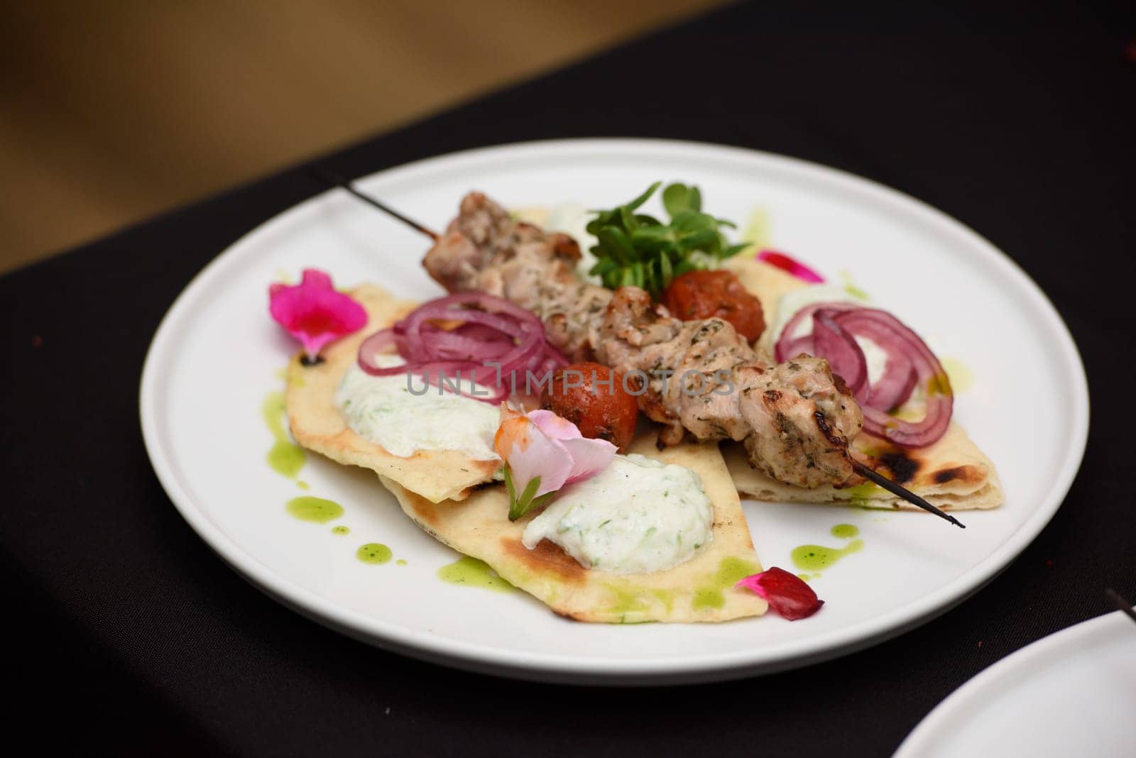 Greek food. souvlaki wrapped in a pita bread on a white plate