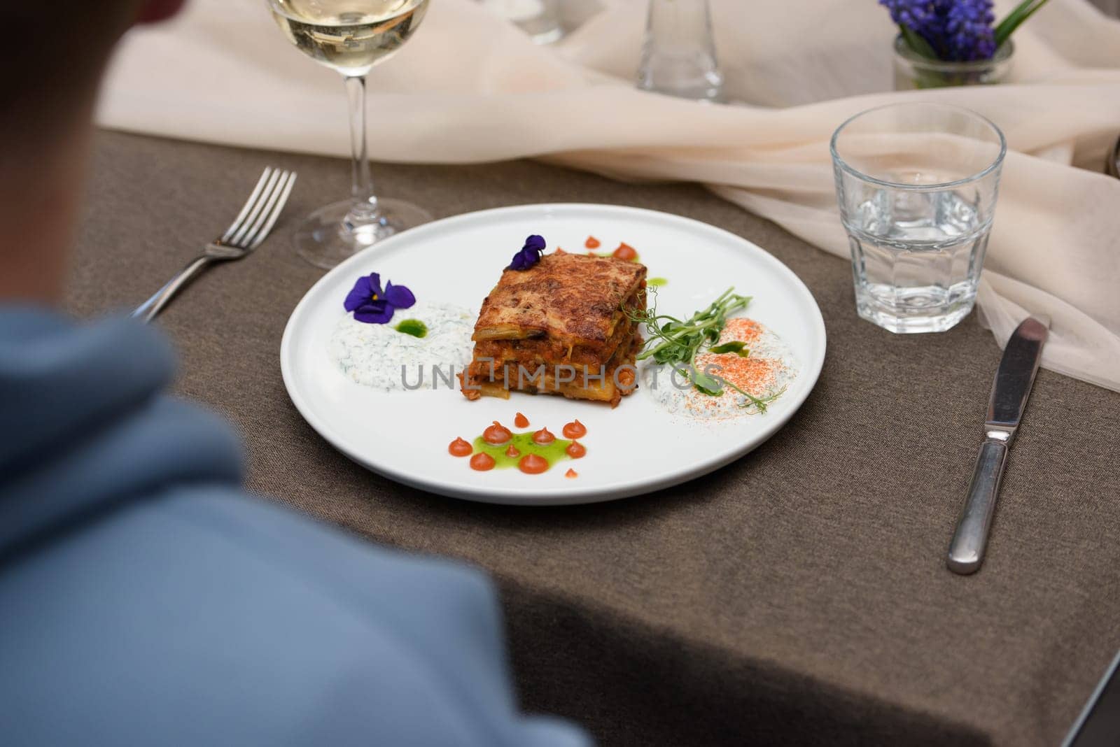 the chef in the restaurant preparing moussaka, baked with beef and cheese