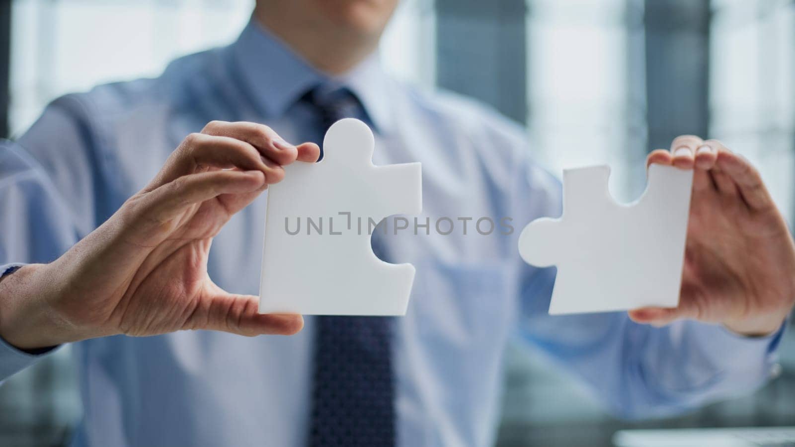 businessman holding a puzzle piece in his hand