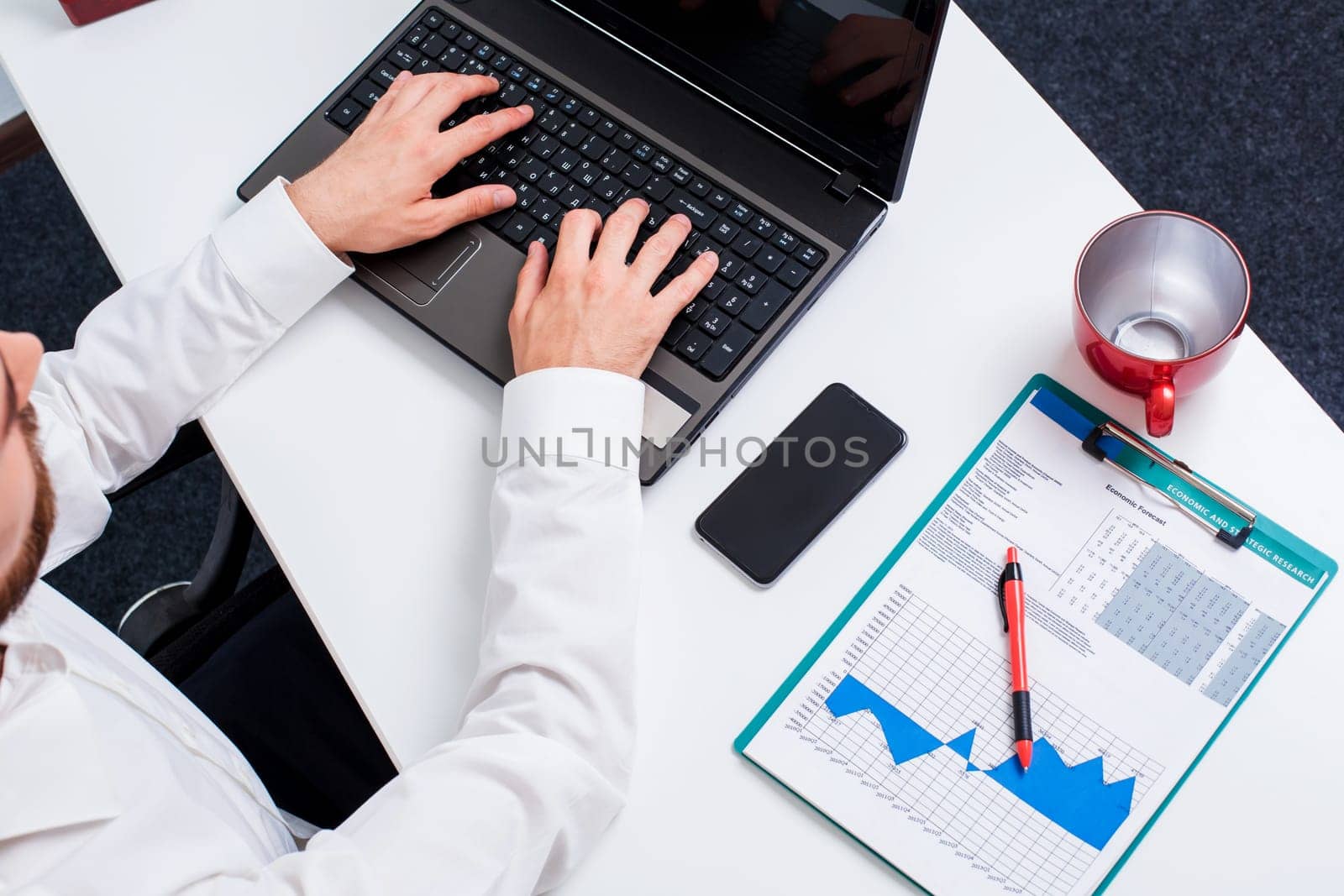 man typing on a laptop keyboard in the office