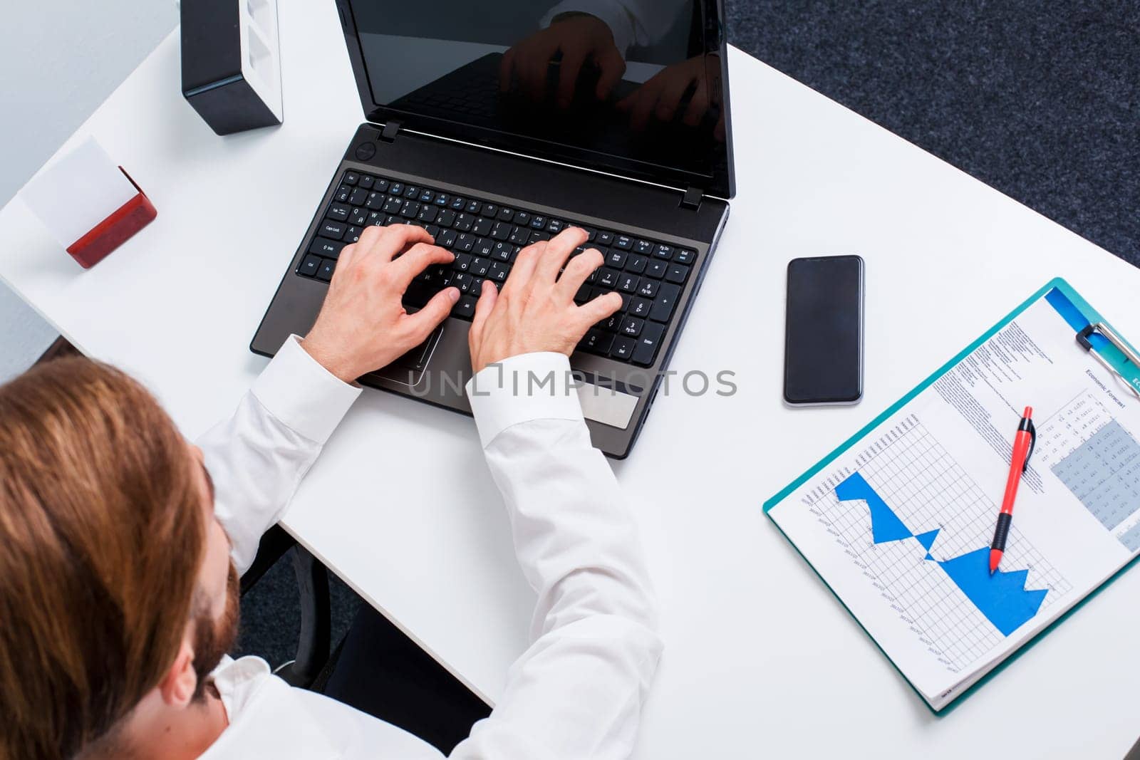 man typing on a laptop keyboard in the office