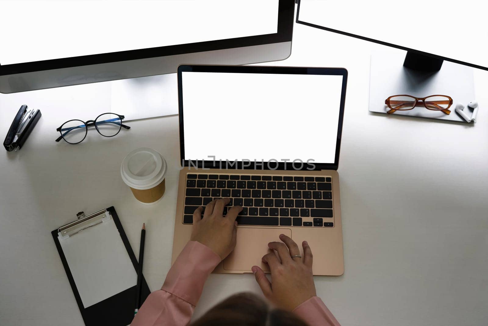 Overhead view businesswoman working with multiple devices in modern workplace.