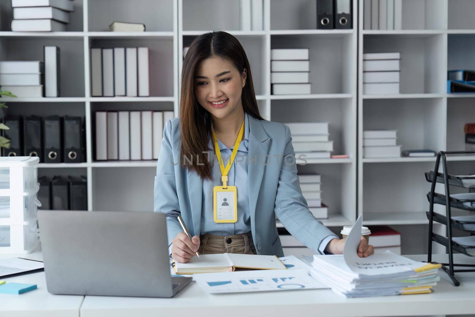 Happy businesswoman analyzing weekly schedule in her notebook.