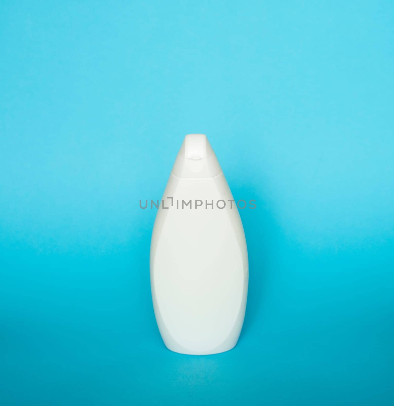 White unbranded dispenser shampoo, gel, soap bottle isolated on blue background. Cosmetic packaging mockup with copy space. by vovsht