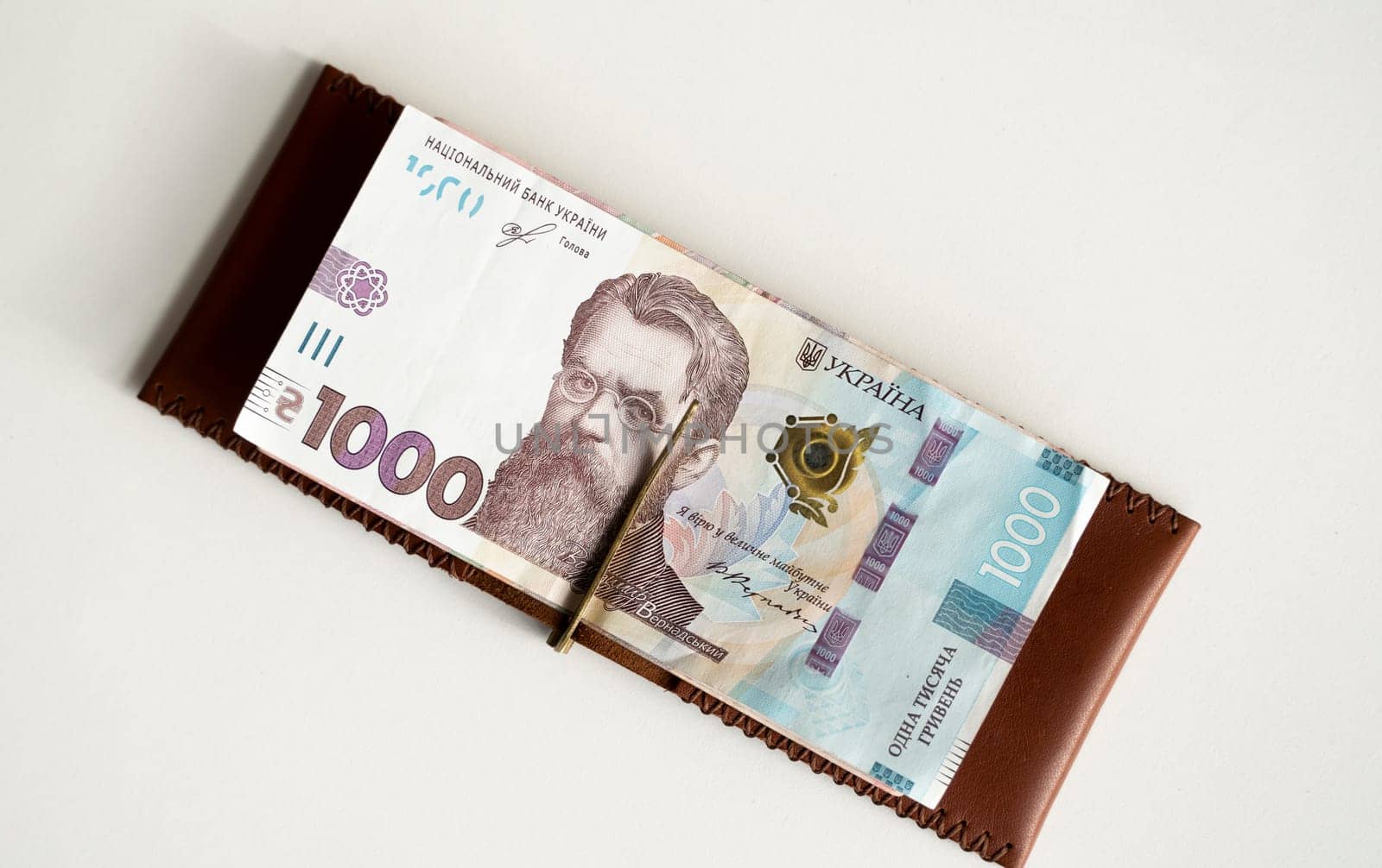 Ukrainian hryvnia money in leather money clip, wallet. Ukraine money on white background with. Currency of Ukraine. Accessories. Money, financess, economy, saving