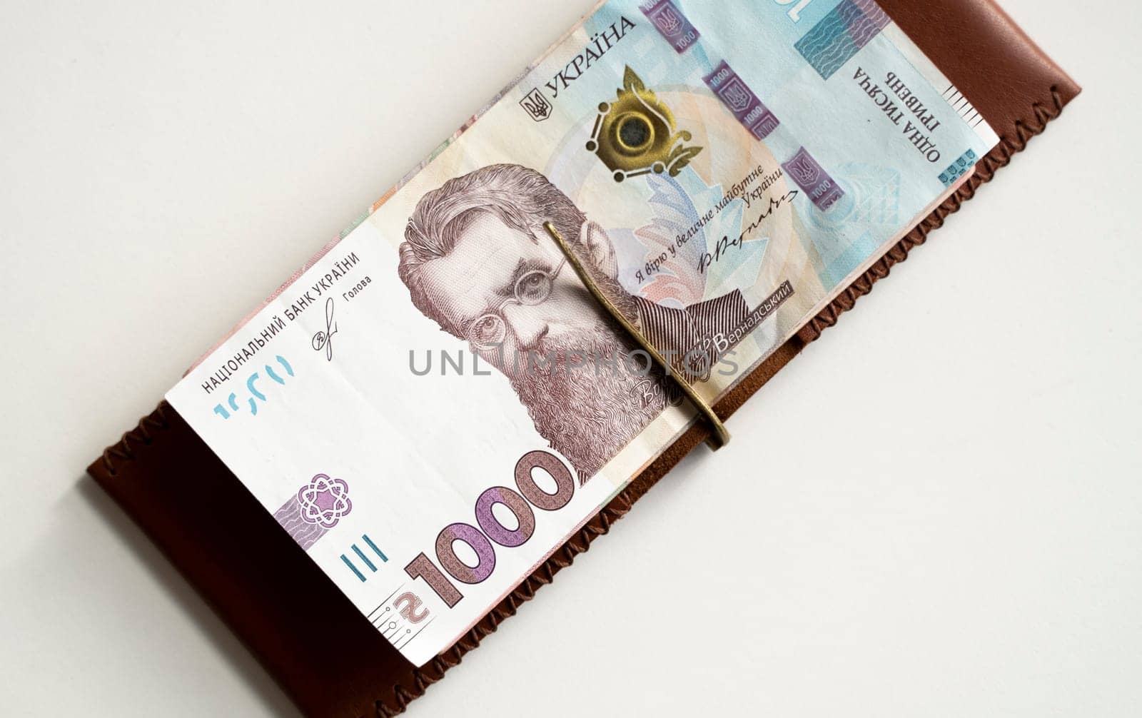 Brown leather money clip, purse with ukrainian hryvnia banknotes. Men's genuine leather wallet. Accessories. Money, financess, economy, saving. by vovsht