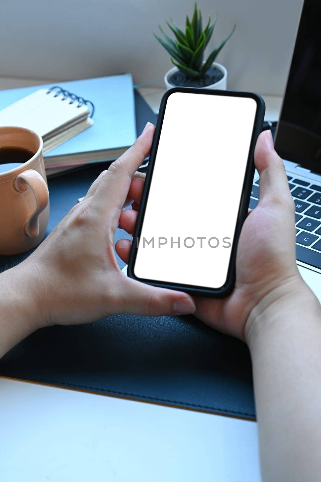 Man hands holding mock up mobile phone with empty screen.
