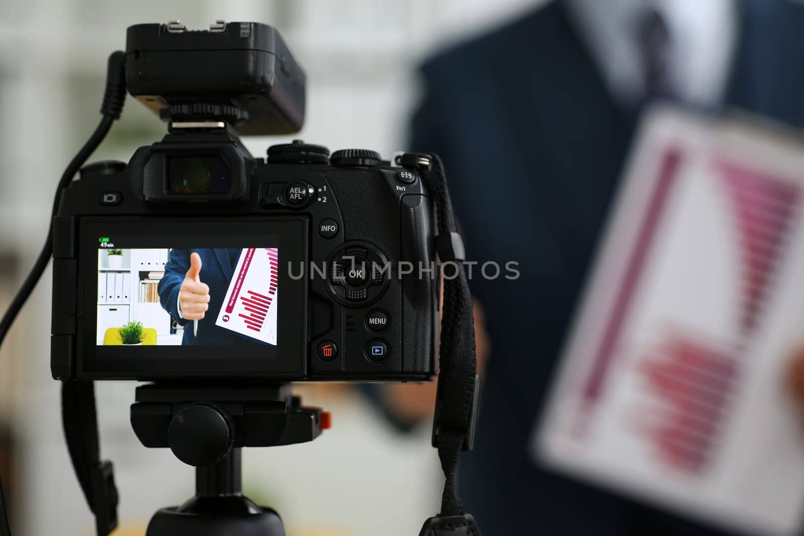 Male in suit and tie show stats graph pad making promo videoblog or photo session in office camcorder to tripod closeup. Vlogger selfie sale solution or finance advisor management information