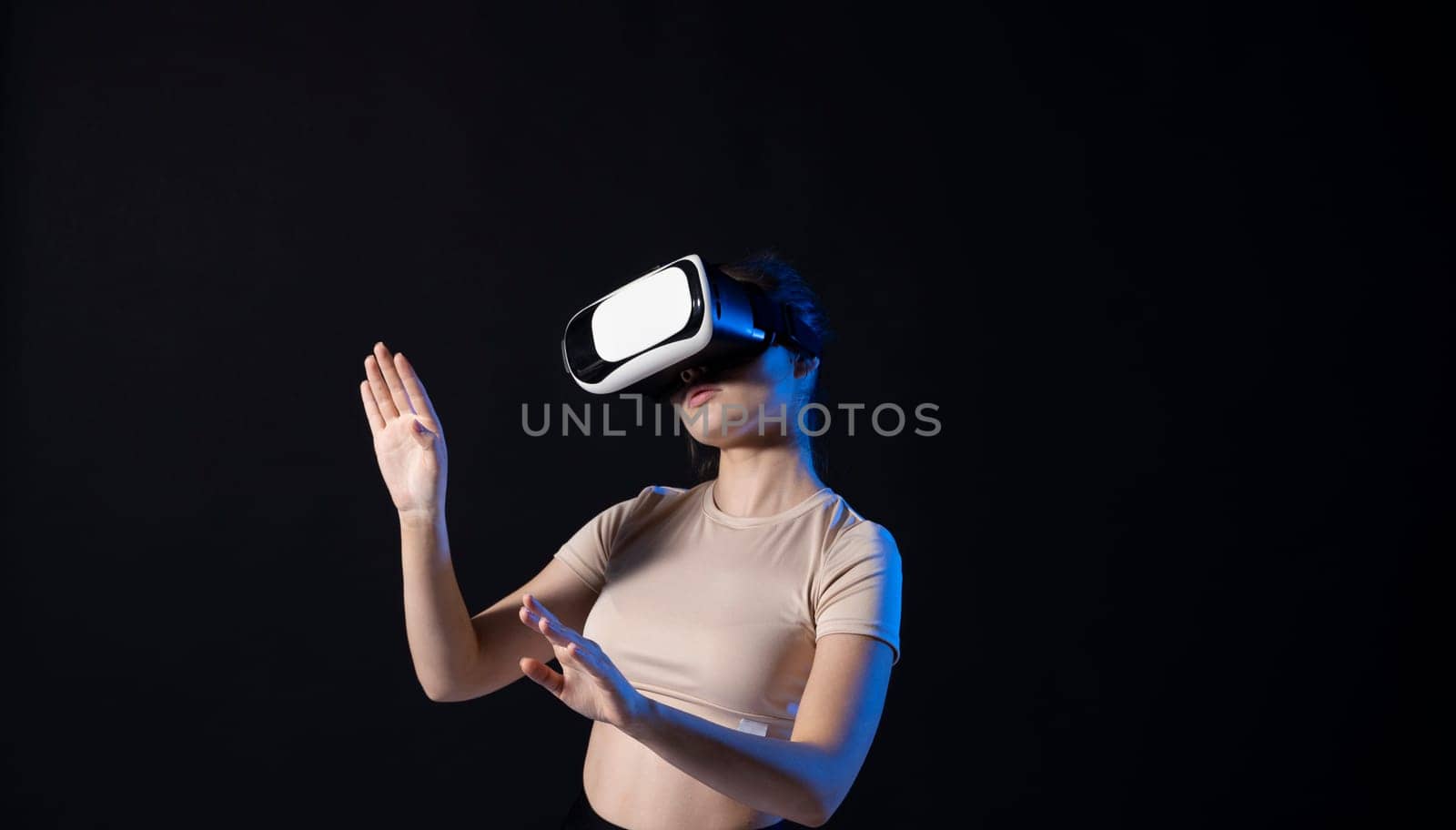 Woman in VR headset looking up at the objects in virtual reality while playing a game or watching 3d movie. Future technology concept