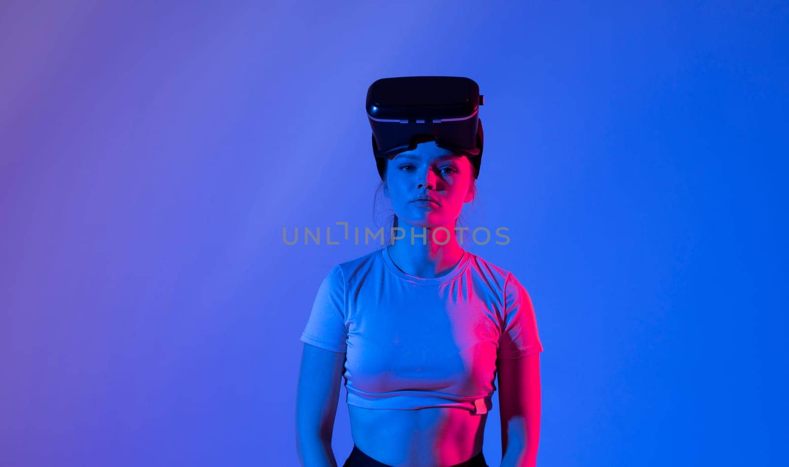 Close up of young woman stands in studio wearing VR glasses and swiping scrolling zooming with hands in a virtual space while interacting with a objects in a metaverse. Virtual reality technology