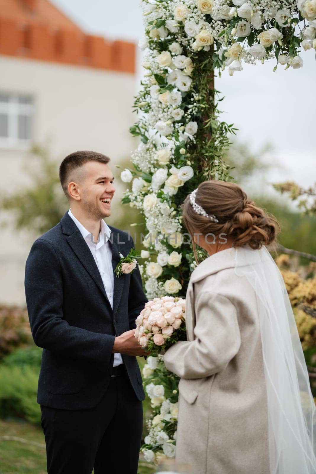 wedding ceremony of the newlyweds in a country cottage on a green hill