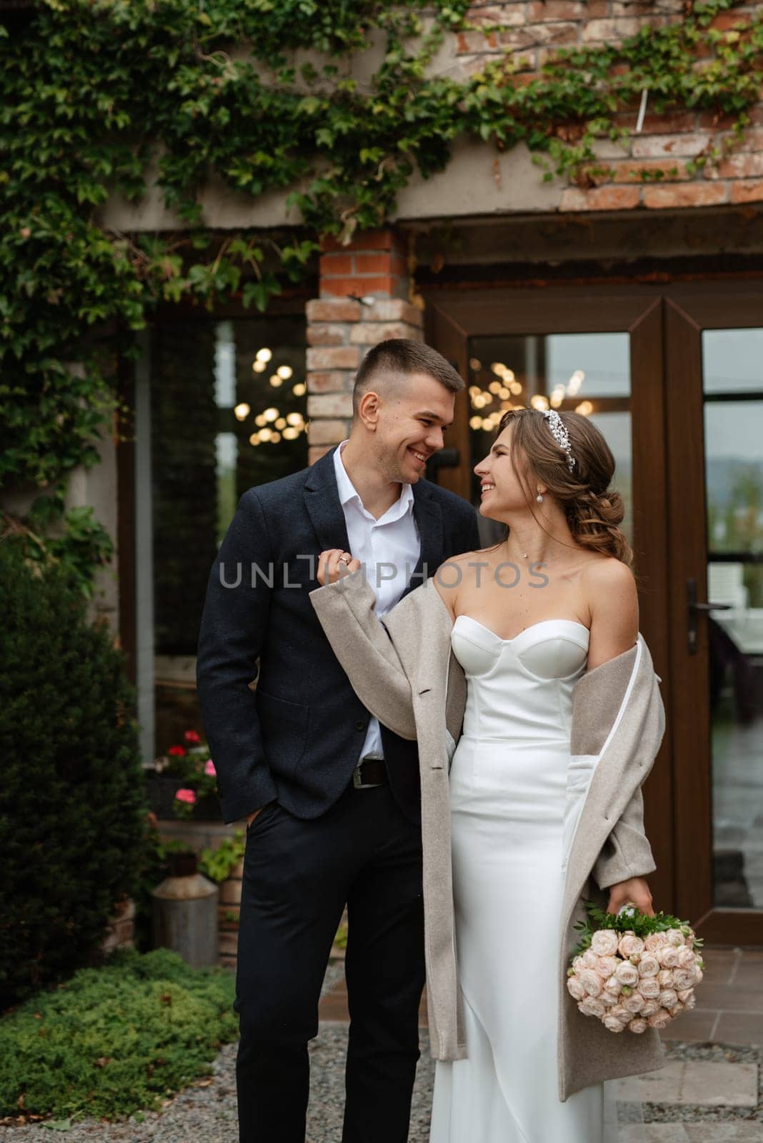 portrait of a young couple of bride and groom on their wedding day in a country cottage