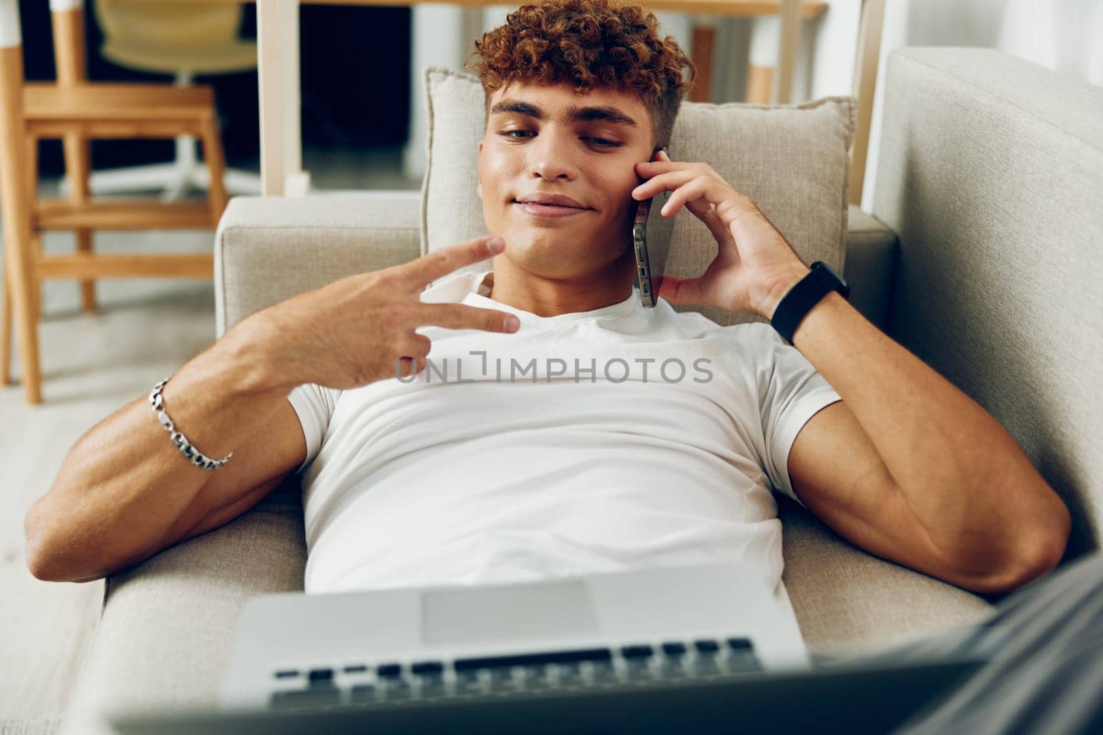 man interior looking internet lifestyle male curly person laptop notebook business modern online couch caucasian room sitting call