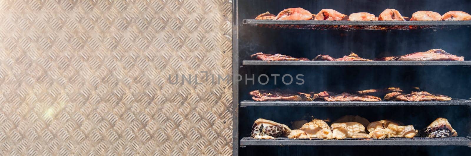 Hot smoked sturgeon. A whole hot-smoked sturgeon lies in the smoking shop. The process of smoking exotic fish. High quality photo