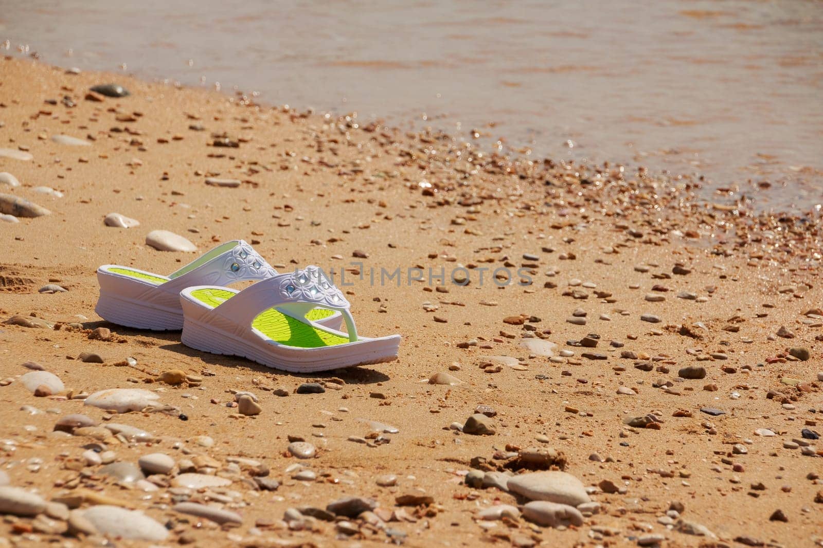 white sandals on the beach. Beach fashion. Copy space