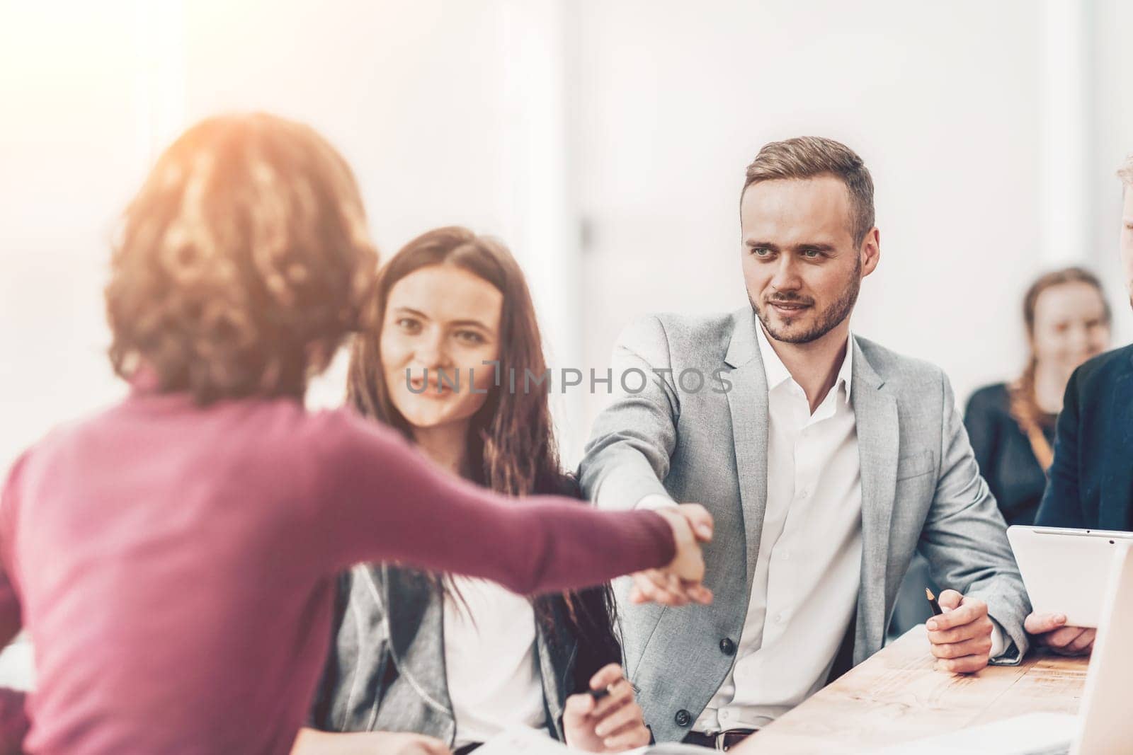young businessman shaking hands with his business partner by SmartPhotoLab