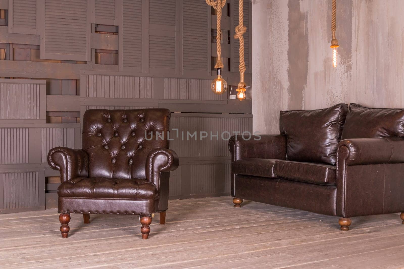 Brown leather armchair and vintage leather sofa. interior composition.retro furniture. Creative design.