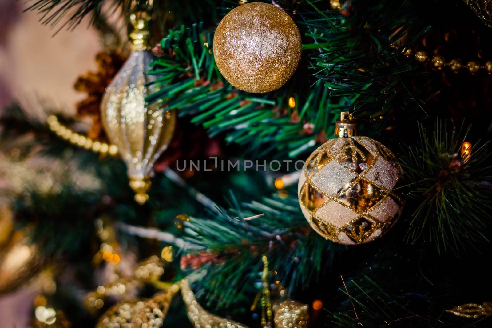 Fir branch with balls and festive lights on the Christmas background with sparkles.