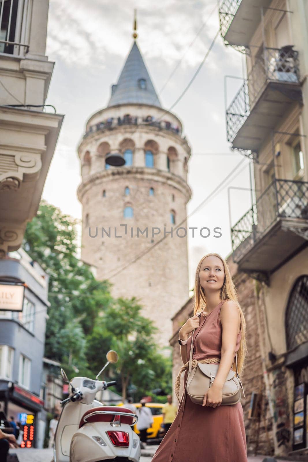 Portrait of beautiful woman tourist with view of Galata tower in Beyoglu, Istanbul, Turkey. Turkiye by galitskaya