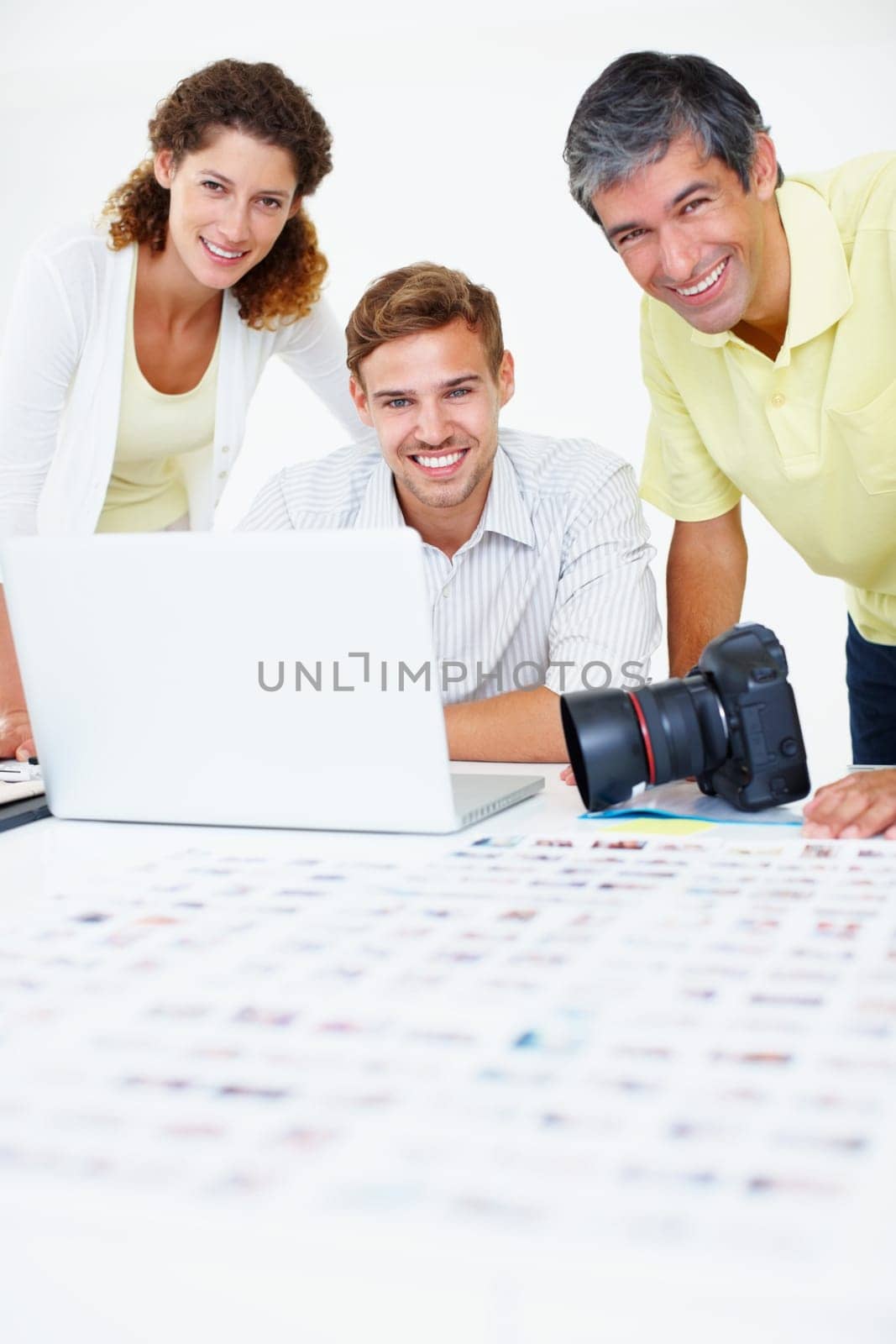 Photographers smiling. Portrait of three photographers using laptop and giving you an attractive smile