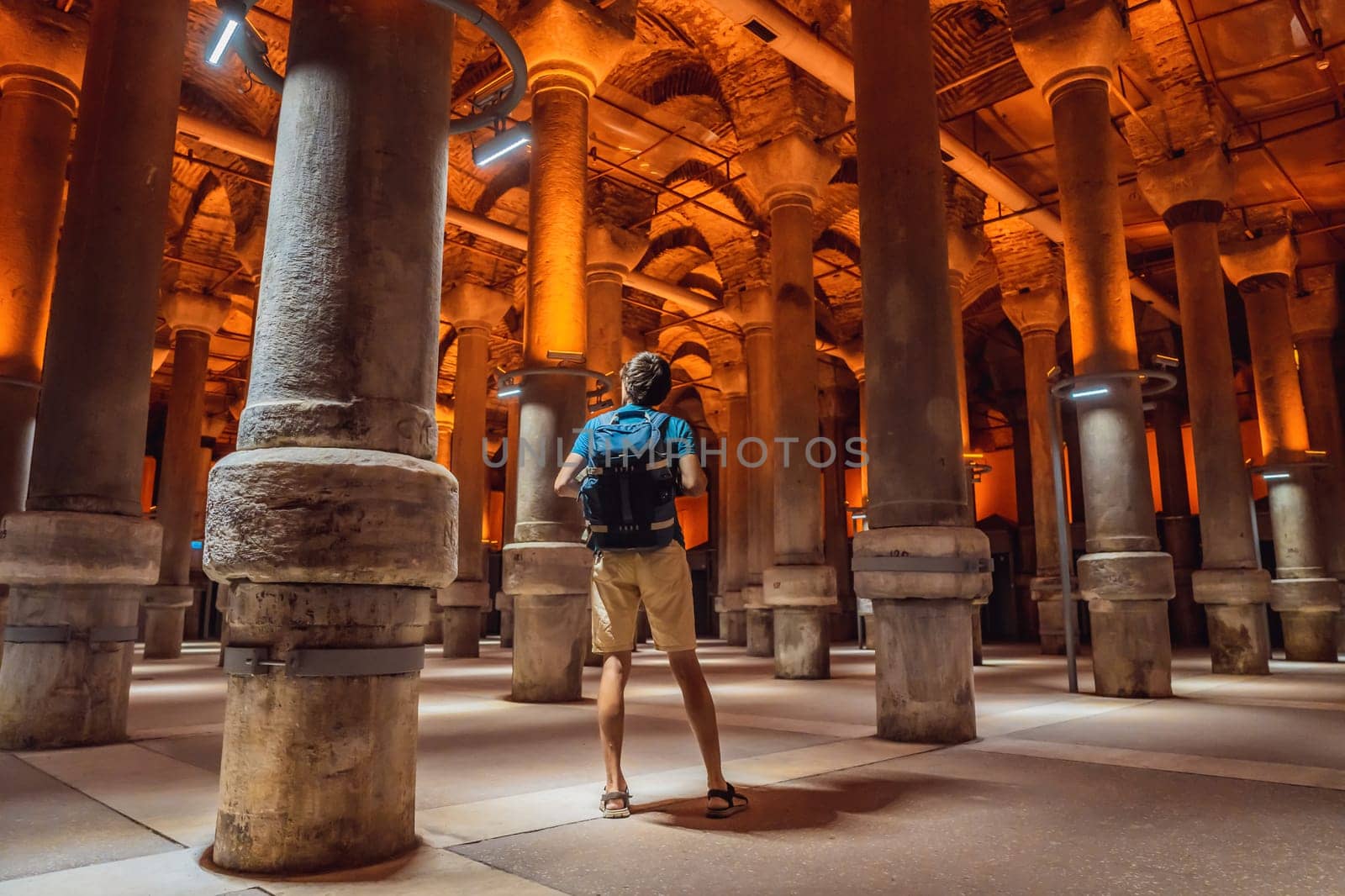 Man tourist enjoying Beautiful cistern in Istanbul. Cistern - underground water reservoir build in 6th century, Istanbul, Turkey, Turkiye.