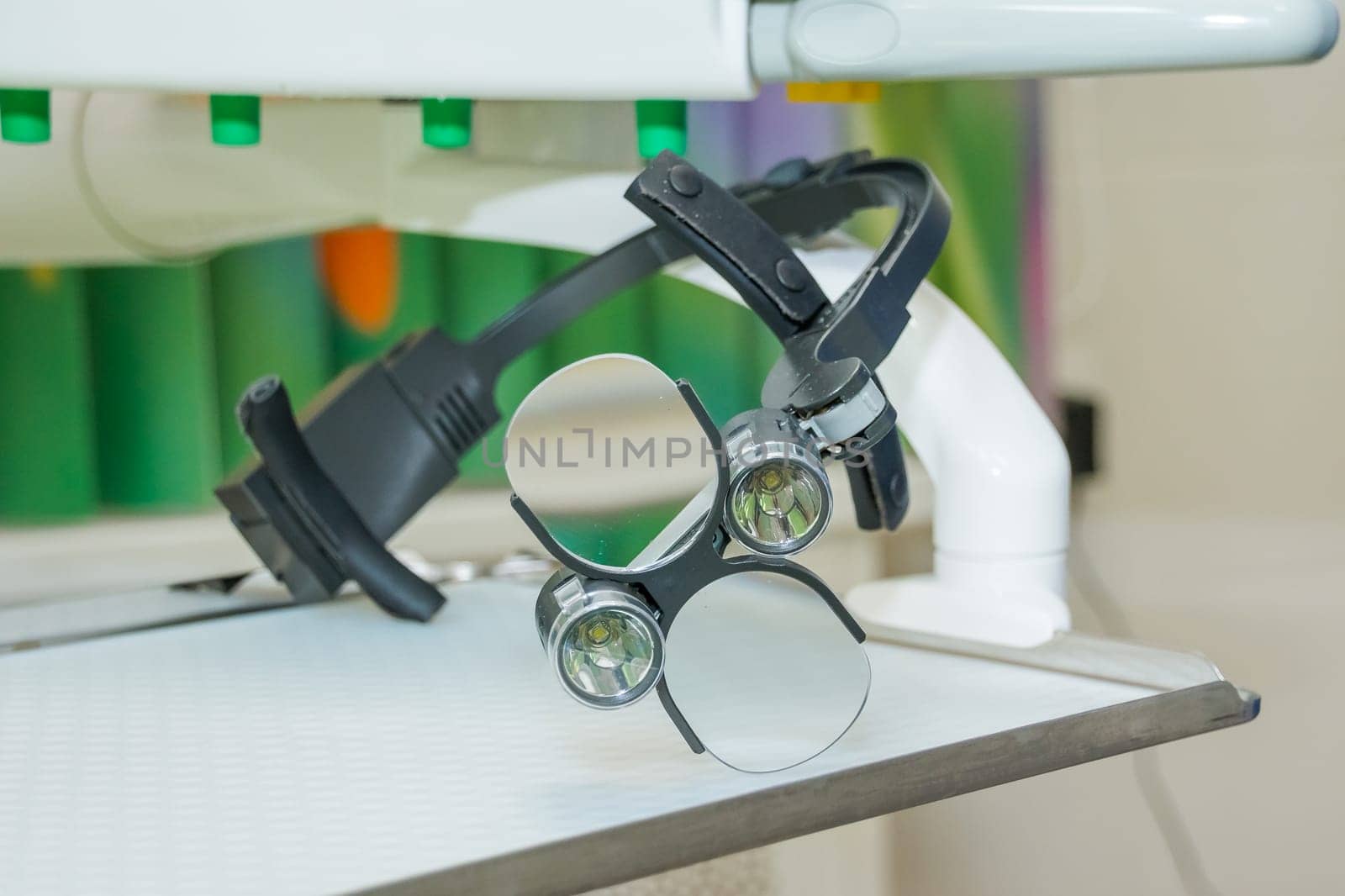 the dental binocular loupes on white tablel in dental office. Dentist goggles, protective glasses in dentist's office. Dentistry.