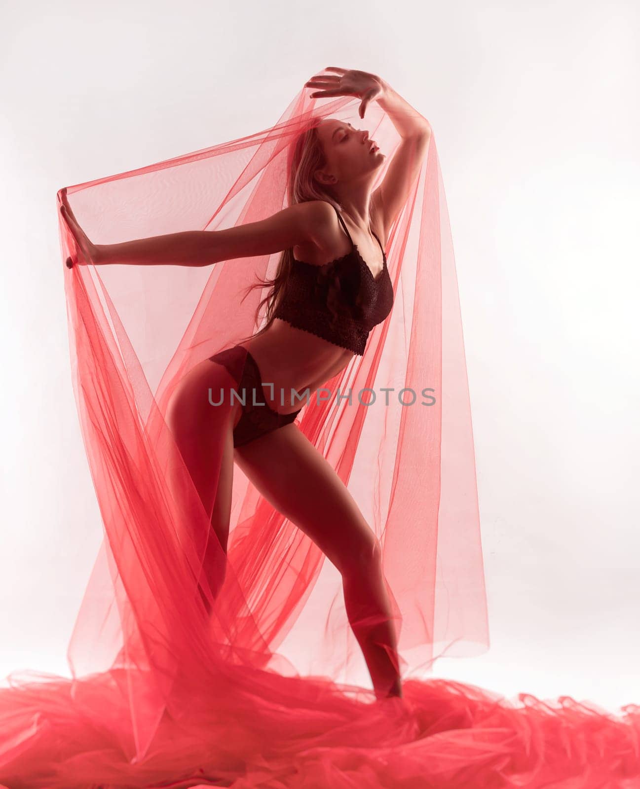 sexy girl in underwear under a transparent red fabric poses erotically and sensually on a white background by Rotozey