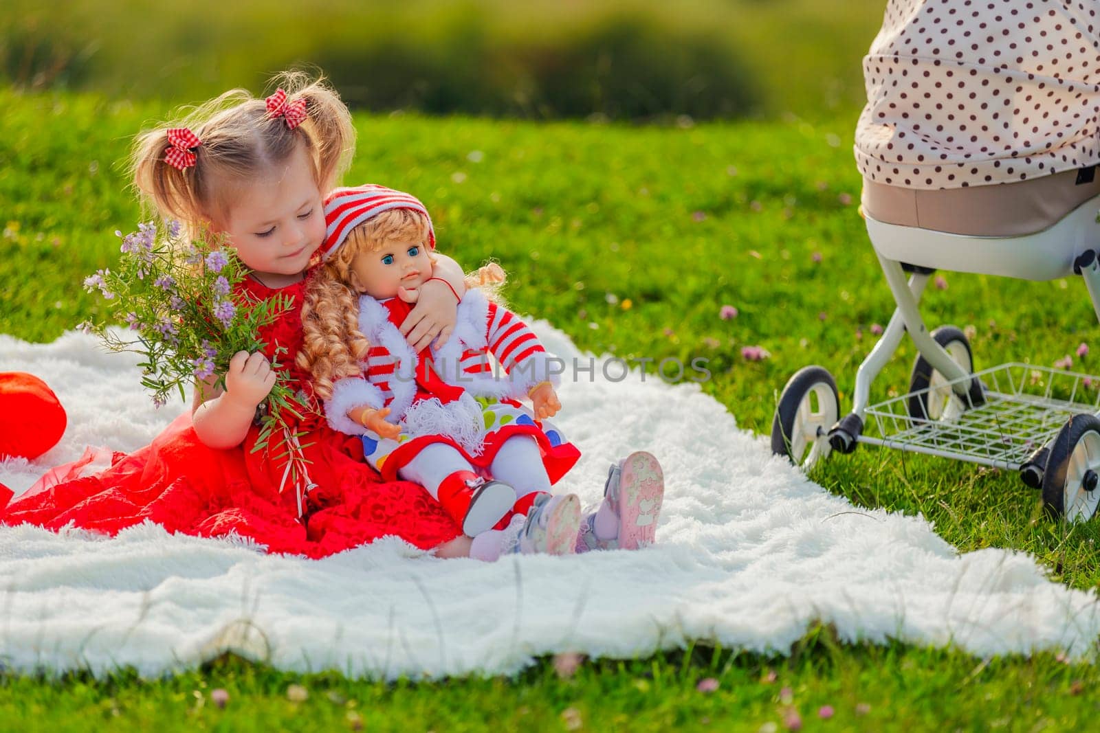 girl playing with her doll in nature by zokov