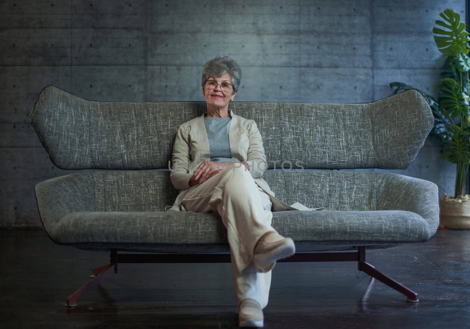 vision, age and people concept - portrait of happy senior woman in glasses sittin on sofa at home