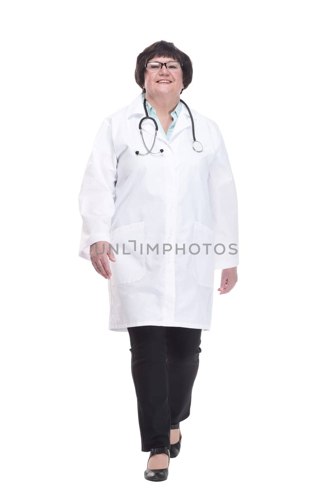older female doctor with a stethoscope walks forward. isolated on a white background.