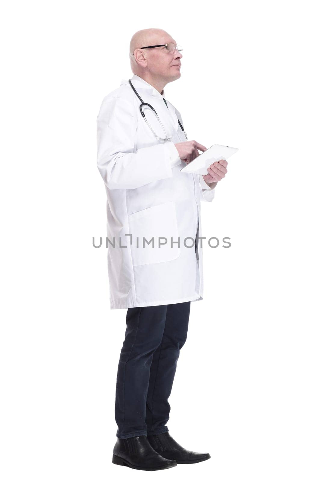 side view. doctor with a digital tablet looking at a white screen. isolated on a white background.