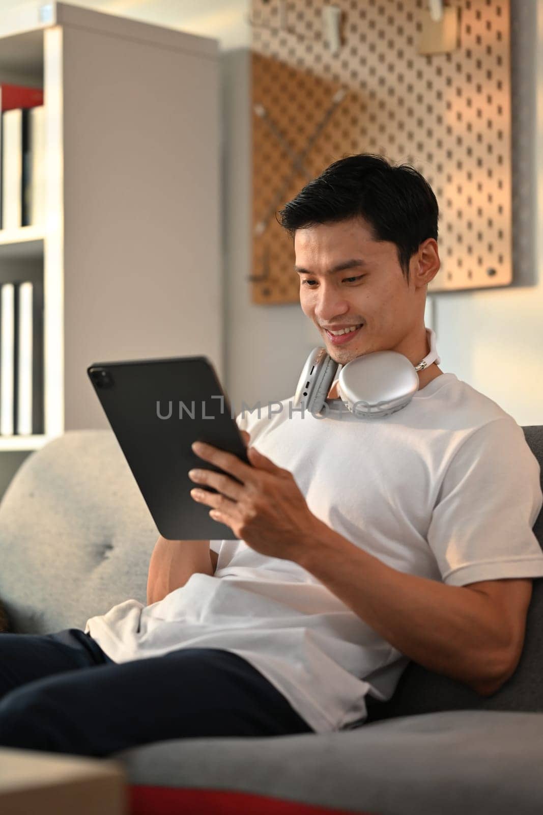 Satisfied asian man freelancer communicating in social media, checking email on digital tablet.