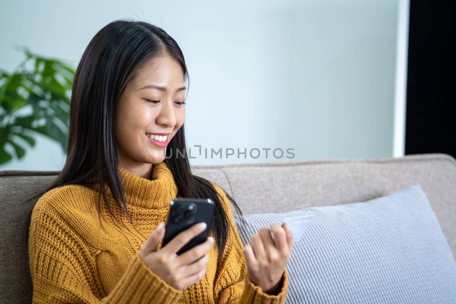Happy smart young woman Asian using smartphone for shopping, mobile shopping, beautiful woman doing online purchases by wuttichaicci