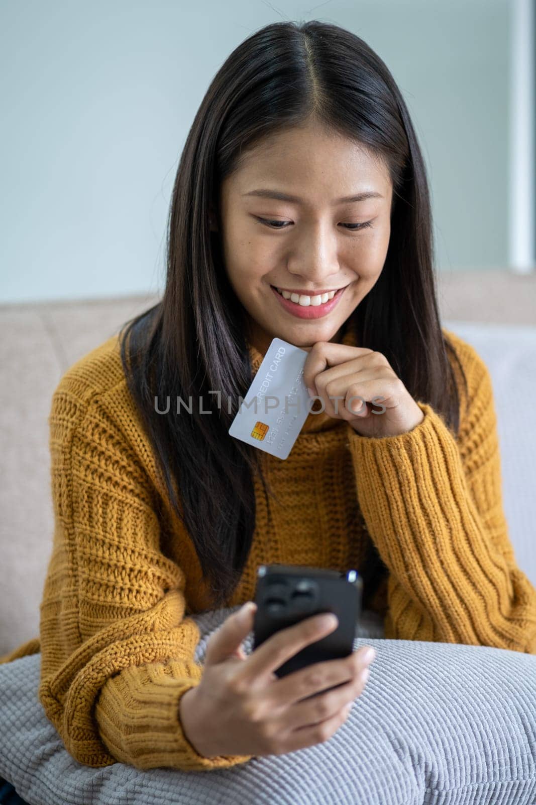 Happy smart young woman Asian using smartphone for shopping, mobile shopping, beautiful woman doing online purchases by wuttichaicci