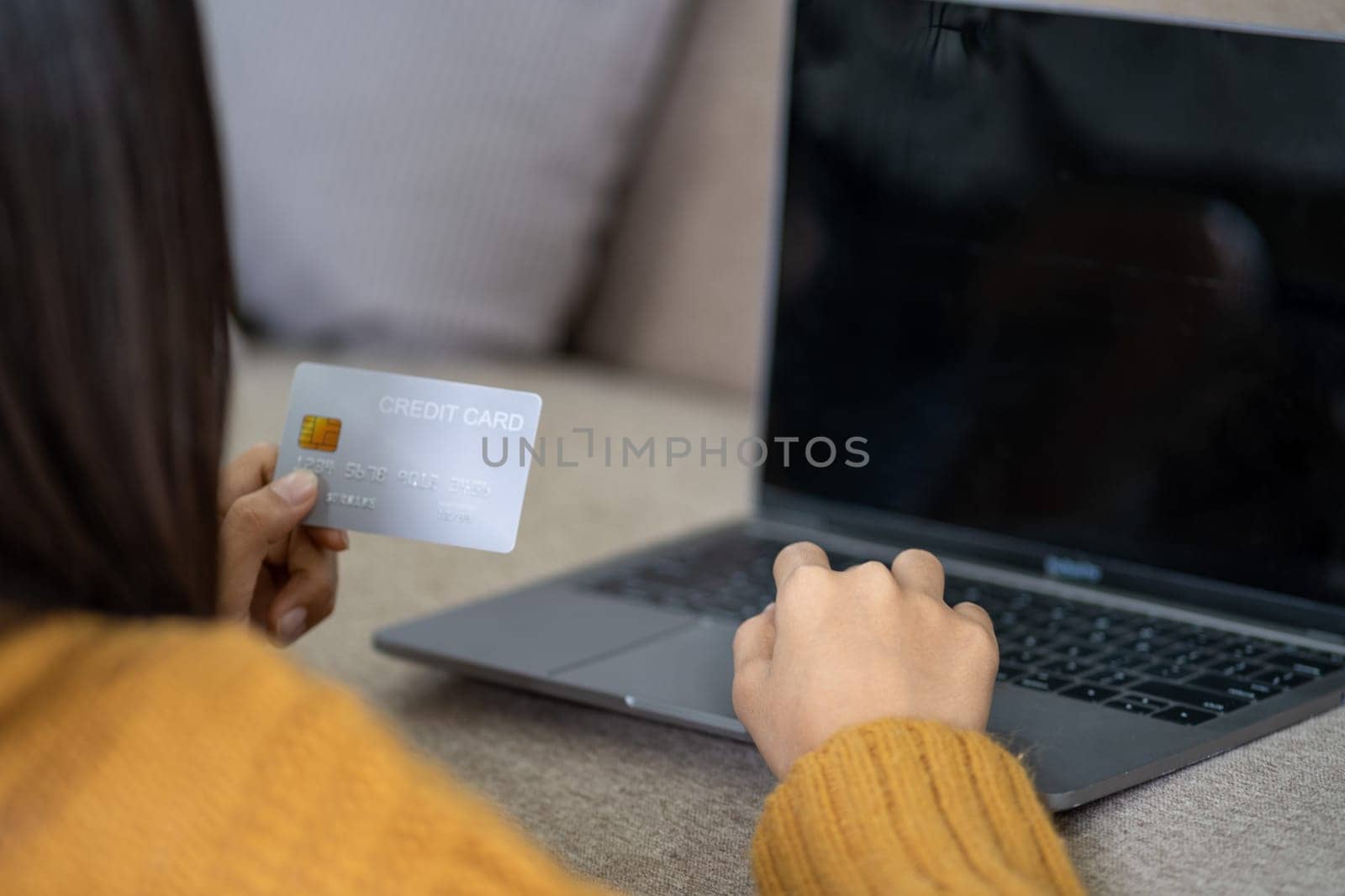 Smart Happy young woman holding credit card and using laptop computer for purchases online market, teenager girl doing online payment, Young woman holding a card for business. High quality photo