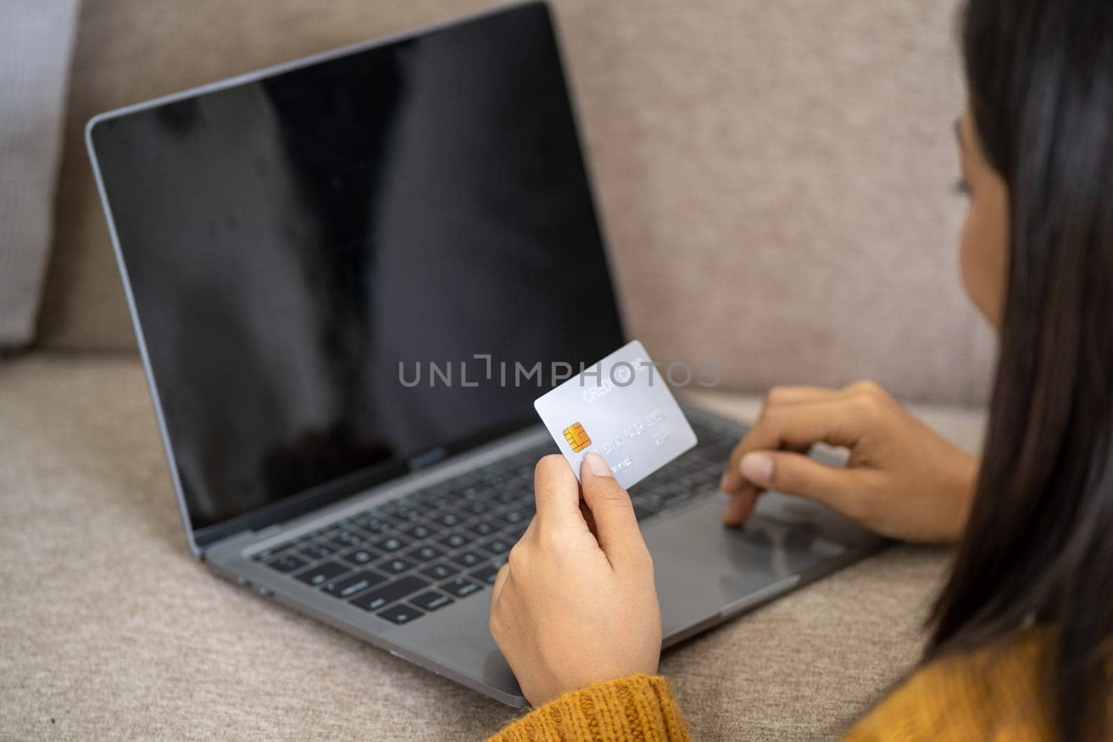 Smart Happy young woman holding credit card and using laptop computer for purchases online market, teenager girl doing online payment, Young woman holding a card for business. High quality photo