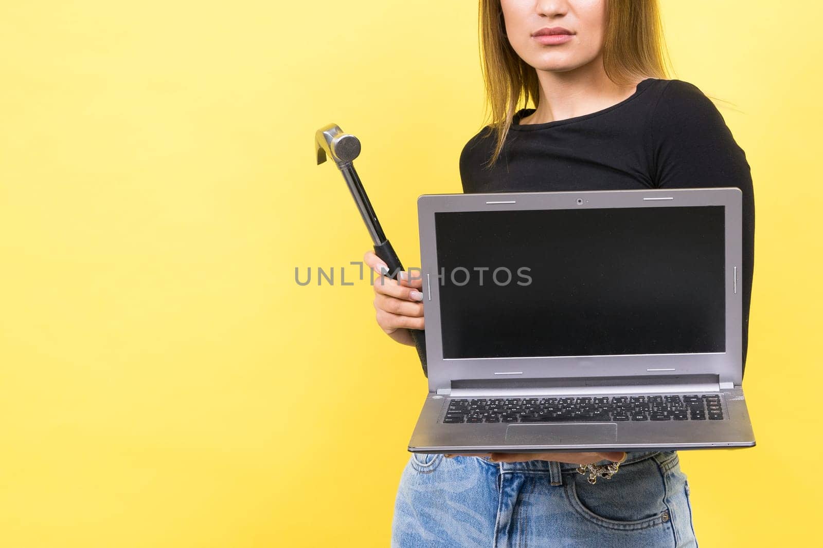 Laptop Repair. Female with hammer and laptop on yellow background by Zelenin