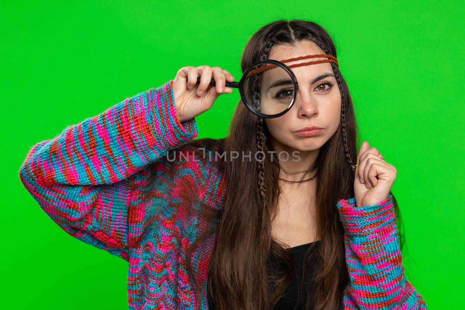 Investigator researcher scientist woman holding magnifying glass near face, looking into camera with big zoomed funny eyes, searching, analysing. Girl isolated on chroma key background, green screen