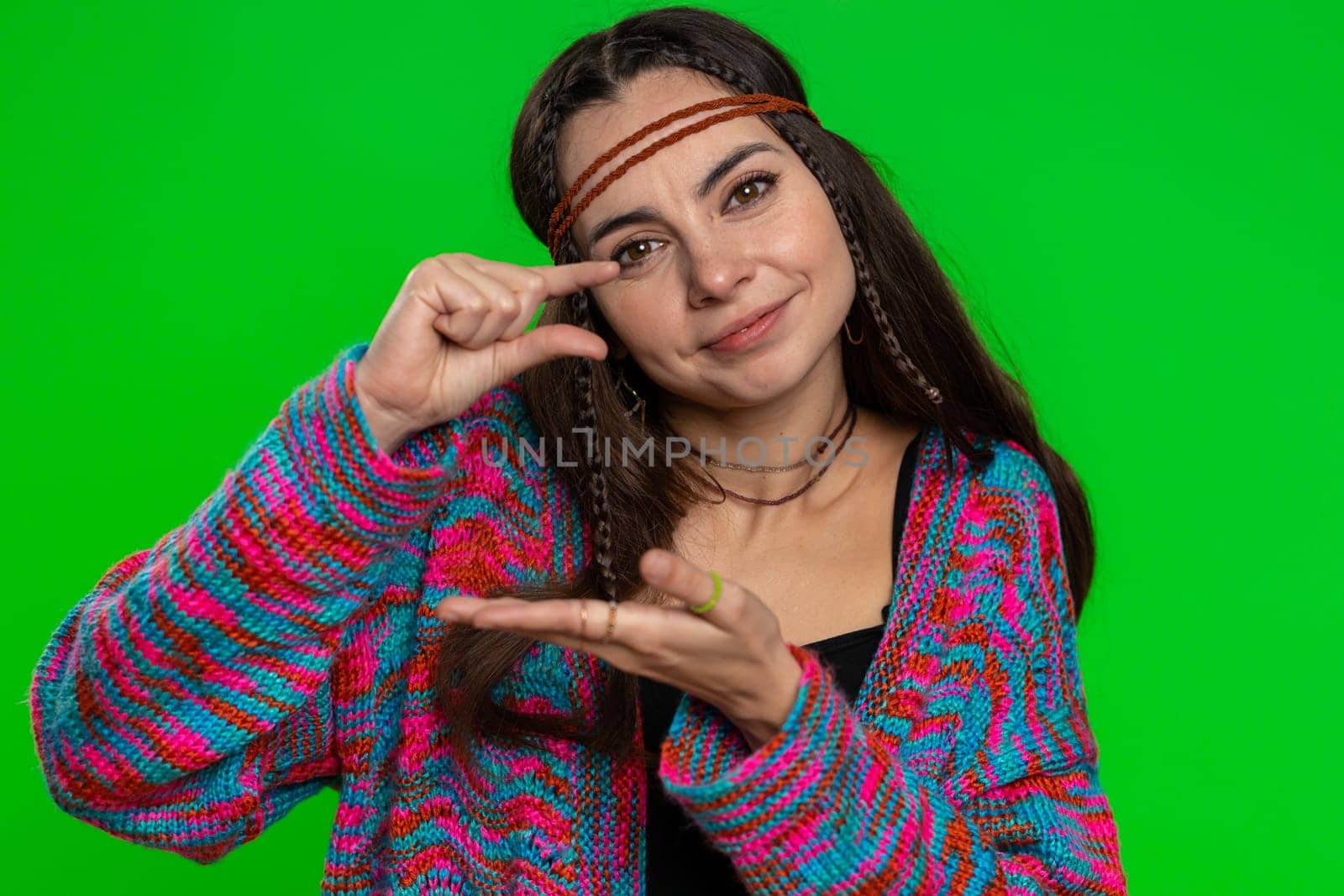 Need some more, please give me. Woman showing a little bit gesture with sceptic smile, showing minimum sign measuring small size. Hippie girl isolated alone on chroma key background, green screen