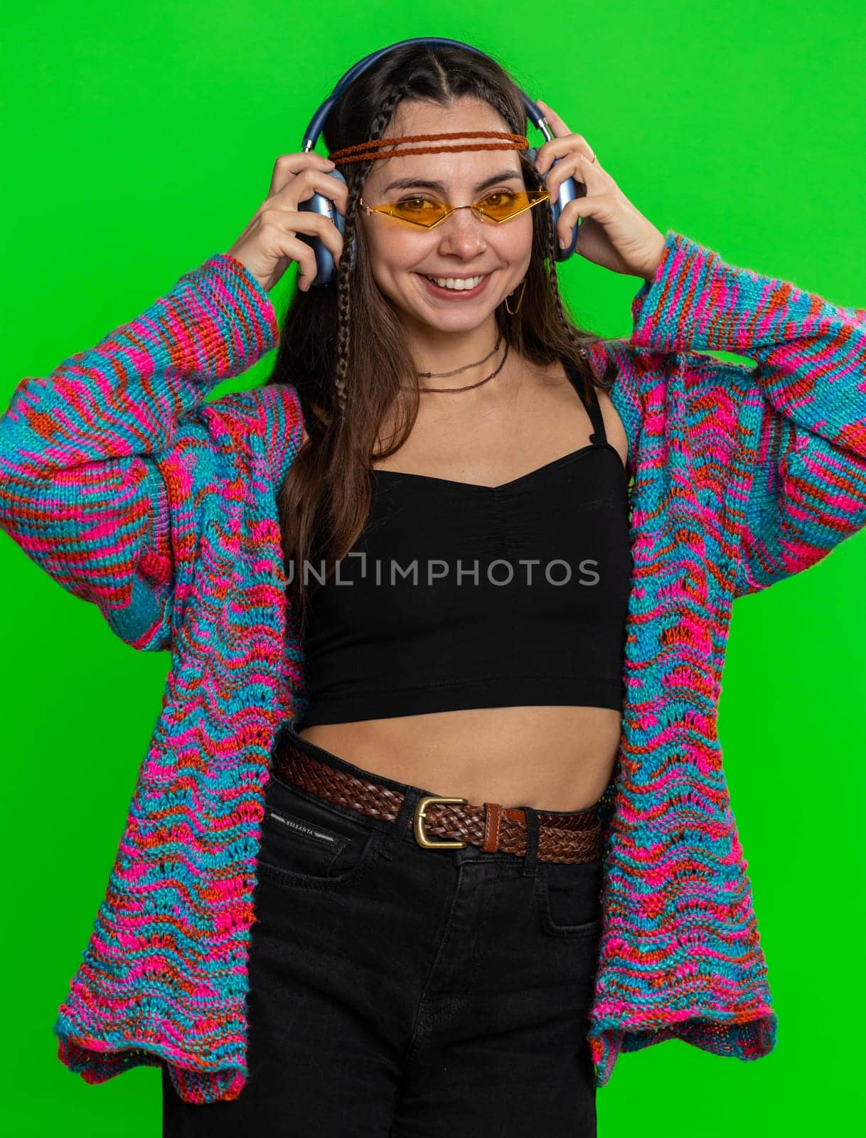 Happy woman in headphones listening music and dancing disco fooling around having fun expressive gesticulating hands, relaxing on party. Girl in sunglasses isolated on studio chroma key background