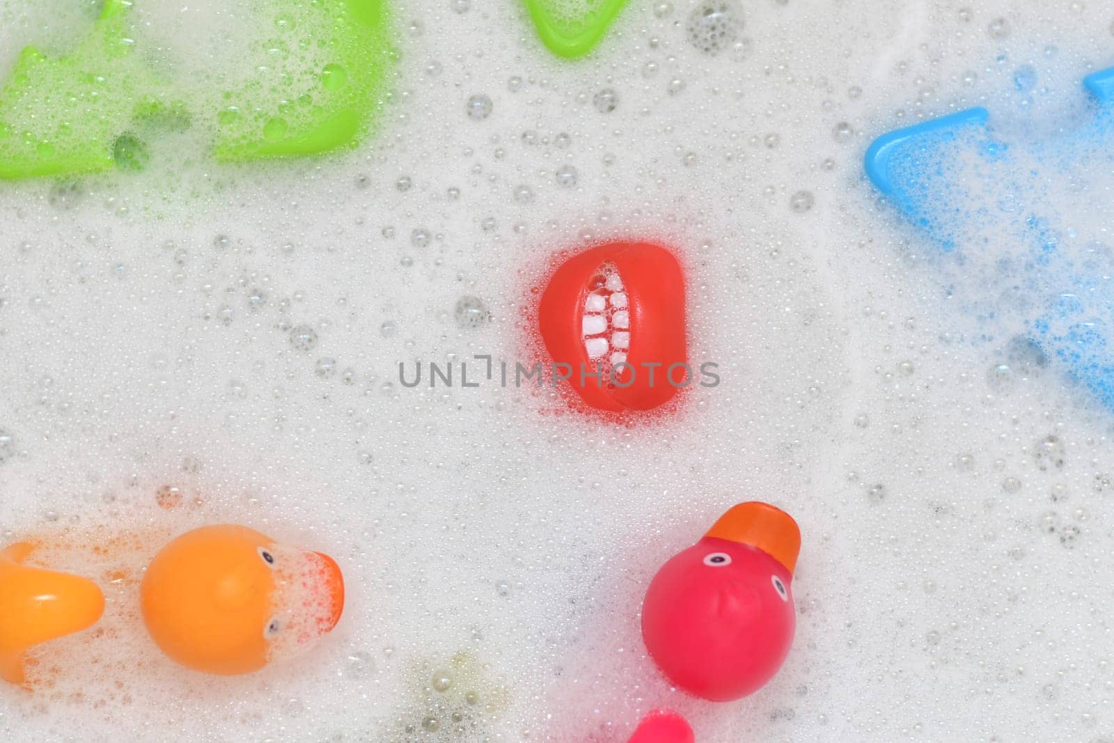 Rubber multicolored toys in a bubble bath for a baby