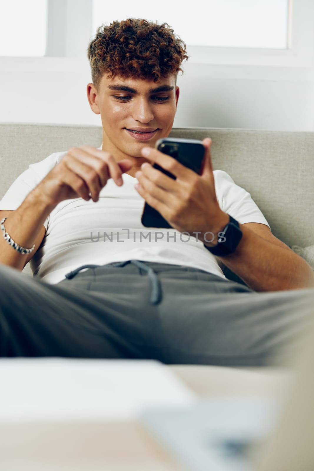 man interior young laptop using text message online phone message business lifestyle selfies by SHOTPRIME