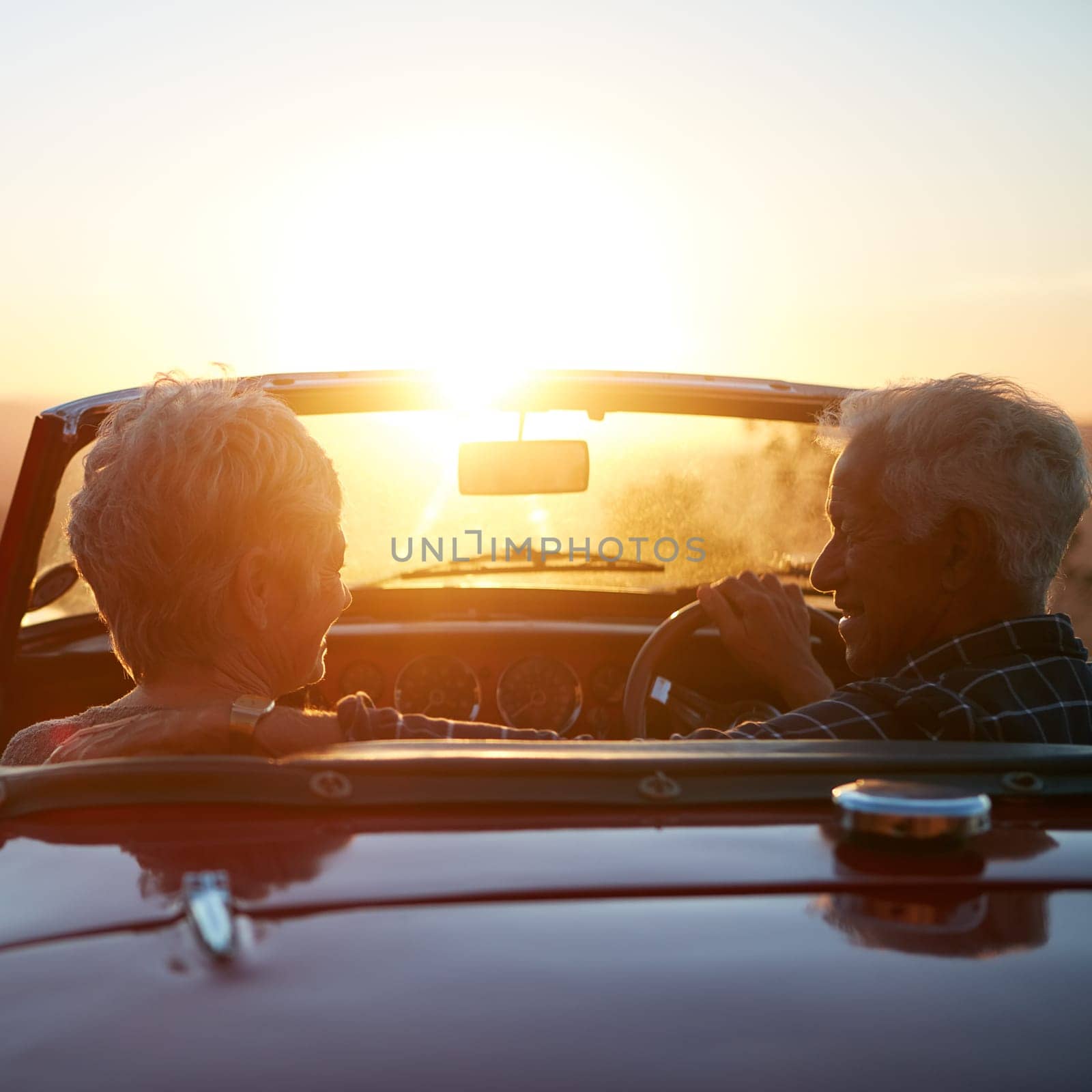 Retirement took them some place wonderful. a senior couple enjoying the sunset during a roadtrip. by YuriArcurs